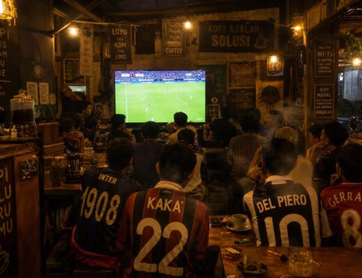 Warkop ramai orang nobar sepak bola malam hari